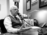A photograph of Phil Williams on the phone working inside his Nashville office.