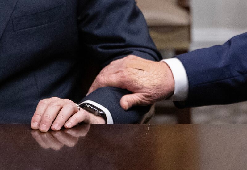 An adhesive bandage is seen on US President Donald Trump's hand (R) as he gestures toward CEO of Dell Technologies Michael Dell during a roundtable discussion in the Roosevelt Room of the White House in Washington, DC, on December 10, 2025. (Photo by ANDREW CABALLERO-REYNOLDS / AFP via Getty Images)