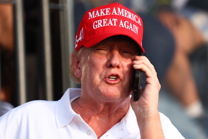 Former U.S. President Donald Trump speaks on the phone at the 18th green during day three of the LIV Golf Invitational - Miami at Trump National Doral Miami on April 07, 2024 in Doral, Florida.