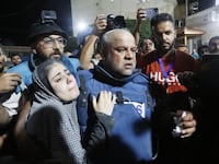 Al Jazeera reporter Wael al-Dahdouh carries his injured son from an ambulance to hospital in Gaza City.