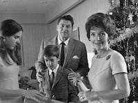 Ronald Regan and family stand with Christmas tree.