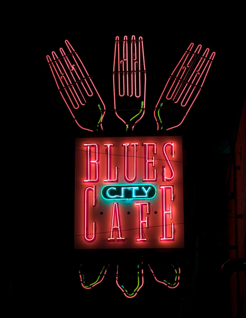 The neon glow of the Blues City Cafe sign on Beale Street in Memphis, Tennessee.