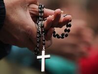 A woman holds rosary beads