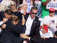 Republican presidential candidate and former U.S. President Donald Trump gestures with a bloodied ear as multiple shots rang out during a campaign rally at the Butler Farm Show in Butler, Pennsylvania, U.S., July 13, 2024.