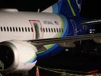 A plastic sheet covers an area of the fuselage of the Alaska Airlines N704AL Boeing 737 MAX 9 aircraft.