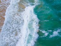 Nature of Aerial view Top-down Beach sand and seawater wave in sunset time. Tropical Sea Andaman Sea