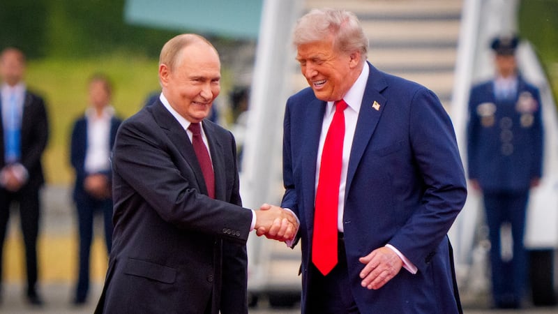 President Donald Trump (R) greets Russian President Vladimir Putin