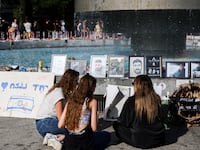 People walk by memorials to those kidnapped by Hamas in Dizengoff Square on November 24, 2023 in Tel Aviv, Israel.