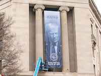 A banner showing President Donald Trump is hung from the Department of Justice, Thursday, Feb. 19, 2026, in Washington, D.C.