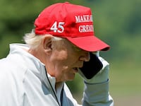 Former U.S. President Donald Trump talks on his phone between shots, as he participates in the Pro-Am tournament ahead of the LIV Golf Invitational at the Trump National Golf Club in Sterling, Virginia, U.S. May 25, 2023.