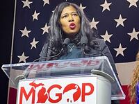 Kristina Karamo gives a speech at a podium for the Michigan GOP