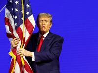 Donald Trump hugs an American flag as he arrives at the Conservative Political Action Conference (CPAC) at the Gaylord National Resort Hotel And Convention Center on February 24, 2024 in National Harbor, Maryland.