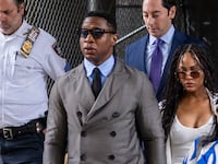 A photo of Jonathan Majors leaving court.