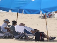 US President Joe Biden (C) relaxes at the beach with First Lady Jill Biden (L) and granddaughter Naomi (2nd L)