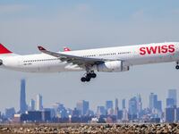 An Airbus A330 passenger aircraft of Swiss airlines arrives from Zurich at JFK International Airport in New York as the Manhattan skyline looms in the background on February 7, 2024. (Photo by Charly TRIBALLEAU / AFP via Getty Images)