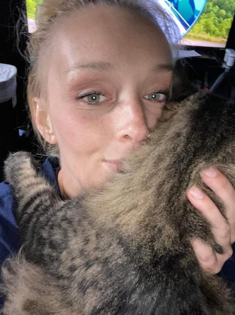 The cat Miss Sassy is held by a woman.