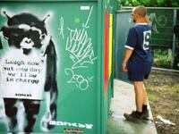 A stencil artwork of an ape by Banksy is pictured on a toilet block at the Glastonbury festival at Worthy Farm on June 25, 2000 in Pilton, United Kingdom.