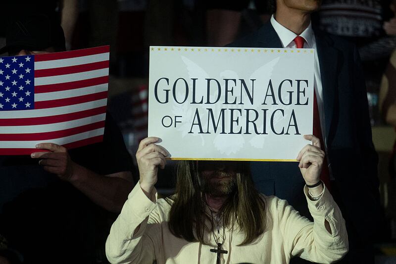 Trump supporters in Michigan waved signs that read “Golden Age of America” during a speech to mark his first 100 days in office Tuesday.