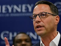 Josh Shapiro raises his index finger while speaking at an event.