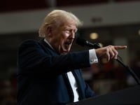 Donald Trump points toward a crowd.