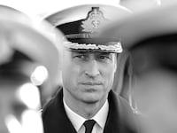 A black and white image of Prince William seen between soldiers