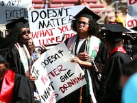 Protesters hold signs to raise awareness of sexual assault on campus