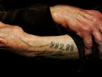 Auschwitz survivor Mr. Leon Greenman, prison number 98288, displays his number tattoo.