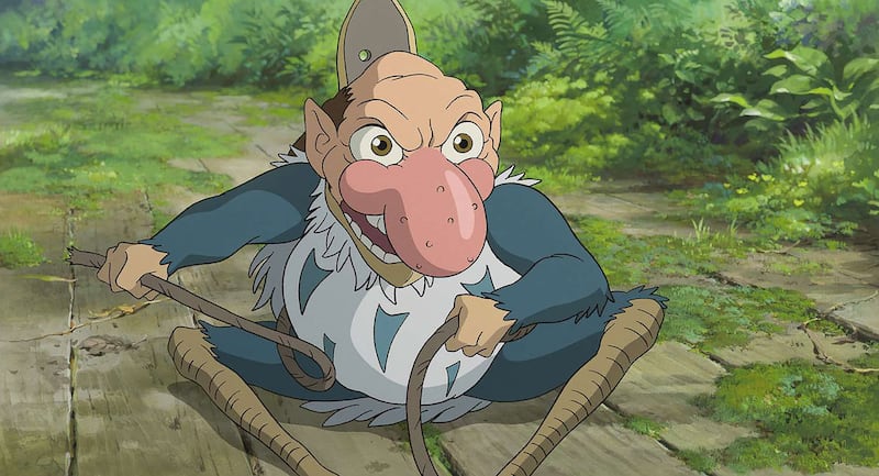 The magic man inside of the Grey Heron reveals himself as he sits on the ground in a still from ‘The Boy and the Heron’