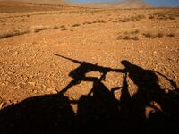 A picture taken on an army-organized press tour shows the silhouette of a Lebanese army soldier manning a machine gun on a hill they recently took from the Islamic State (IS) group in Jurud Ras Baalbek on the Lebanese-Syrian border on August 28, 2017