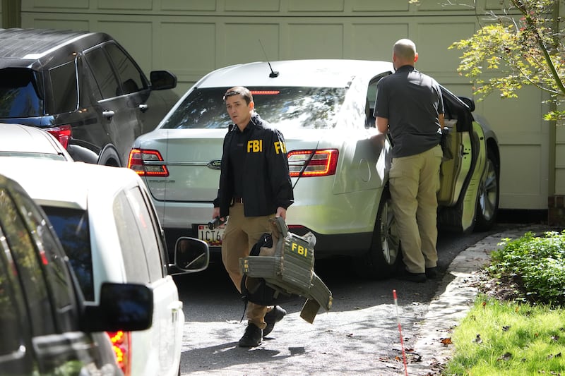 FBI agents work outside the home of John Bolton, former national security adviser to President Trump, August 22, 2025 in Bethesda, Maryland. The FBI conducted an early morning court-authorized search of Bolton's home.