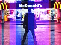 A glitched still from Morgan Spurlock’s ‘Super Size Me’ showing Morgan standing in front of a McDonald’s at night.