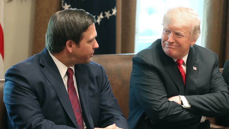 Florida Governor Ron DeSantis sits next to Donald Trump during a meeting in the Cabinet Room at the White House on December 13, 2018 in Washington, DC.