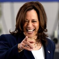 Kamala Harris laughs and points into the crowd at a campaign event.