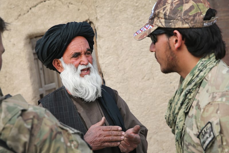 An Afghan interpreter with the U.S. Army's 4th Squadron 2d Cavalry Regiment helps to question a villager during a joint patrol with soldiers from the Afghan National Army in 2014.