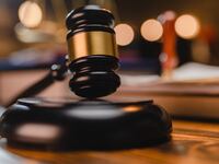 A judge’s gavel rests on a desk.