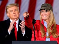 US President Donald Trump claps as Republican incumbent senator Kelly Loeffler speaks during a rally ahead of Senate the runoff in Dalton, Georgia on January 4, 2021. - President Donald Trump, still seeking ways to reverse his election defeat, and President-elect Joe Biden converge on Georgia on Monday for dueling rallies on the eve of runoff votes that will decide control of the US Senate. Trump, a day after the release of a bombshell recording in which he pressures Georgia officials to overturn his November 3 election loss in the southern state, is to hold a rally in the northwest city of Dalton in support of Republican incumbent senators Kelly Loeffler and David Perdue. (Photo by SANDY HUFFAKER / AFP) (Photo by SANDY HUFFAKER/AFP via Getty Images)