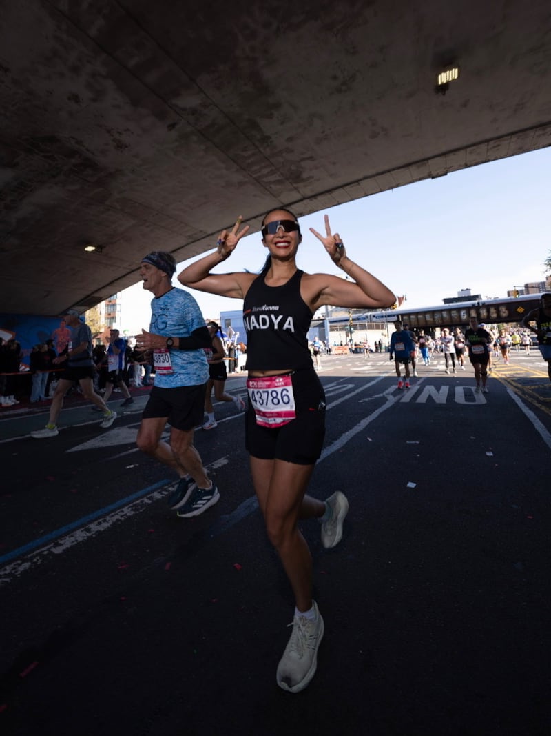 Runner and Influencer Nadya Okamoto is pictured running and posing with peace signs during a race.