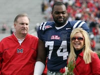 Sean Tuohy, Michael Oher, and Leigh Anne Tuohy during a football game in 2008.