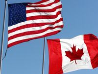 An American & Canadian flag waving in the wind.