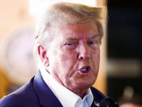 Donald Trump has his mouth partially open as he speaks at an Iowa campaign event.