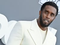 Sean “Diddy” Combs poses in a white suit.