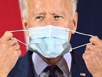 Joe Biden puts on a face mask in October 2020.