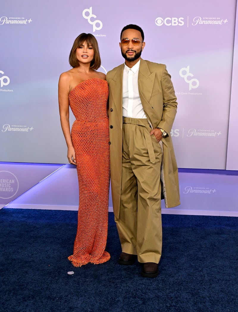 Chrissy Teigen accompanies John Legend to the 2026 52nd American Music Awards in a floor-length beaded dress.