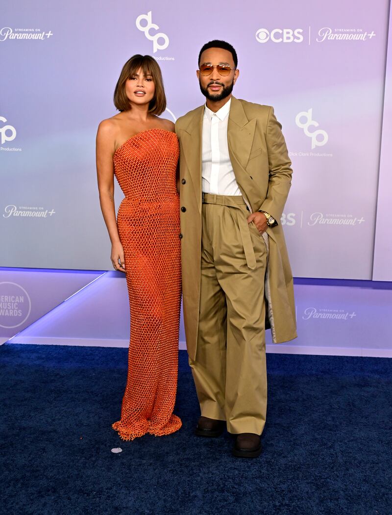 Chrissy Teigen accompanies John Legend to the 2026 52nd American Music Awards in a floor-length beaded dress.