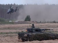 A Eurocopter Tiger attack helicopter and a Puma infantry fighting vehicle of the Bundeswehr, the German armed forces, participate in the Quadriga military exercises involving German, French, Lithuanian and Dutch troops during a Distinguished Visitors' Day on May 29, 2024 near Pabrade, Lithuania.