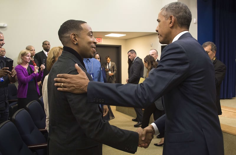 Barack Obama (R) shakes hands with US rapper, entrepreneur, and actor Chris Bridges (