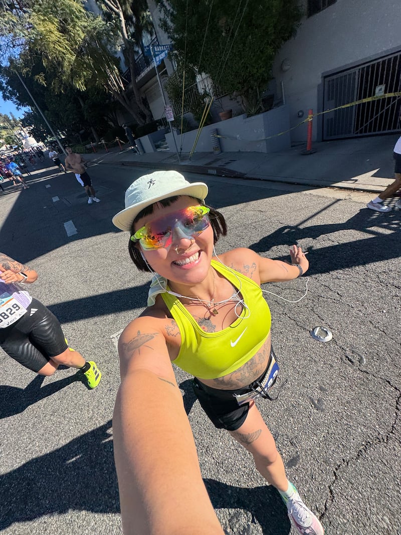 Ameya Okamoto poses for a selfie as she runs in a race.