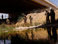 Members of the U.S. Texas National Guard extend razor wire to inhibit migrant crossing, as seen from Ciudad Juarez, Mexico, May 13, 2023.