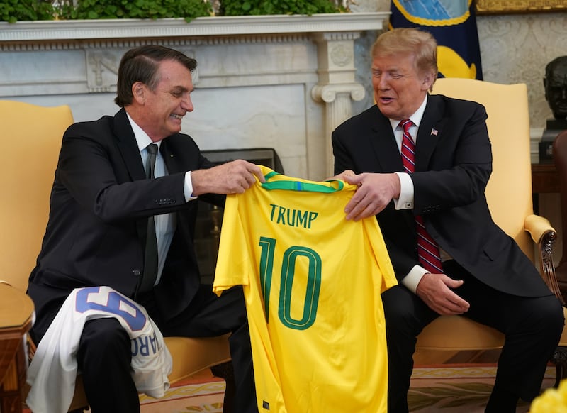 WASHINGTON, DC - MARCH 19: Brazilian President Jair Bolsonaro presents U.S. President Donald Trump with a Brazil national soccer team jersey Number 10 for striker position at the White House March 19, 2019 in Washington, DC. President Trump is hosting President Bolsonaro for a visit and bilateral talks at the White House today. (Photo by Chris Kleponis-Pool/Getty Images)