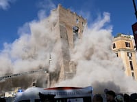 TOPSHOT - Dust rises due to a second collapse of part of the medieval tower "Torre dei Conti" near the Roman Forum in the historic center of Rome on November 3, 2025. (Photo by Tiziana FABI / AFP) (Photo by TIZIANA FABI/AFP via Getty Images)